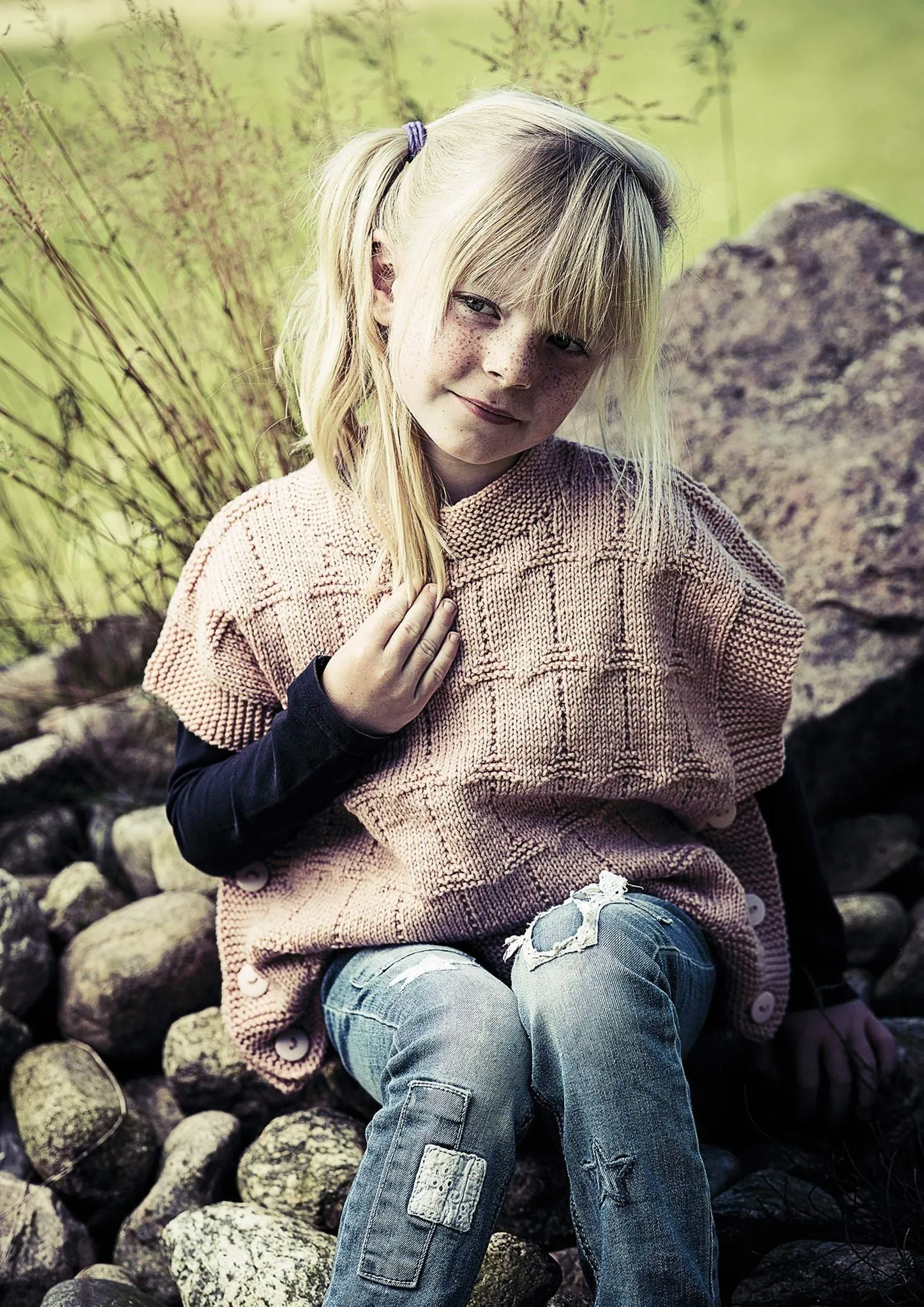 Strikket børneponcho med knapper i siderne